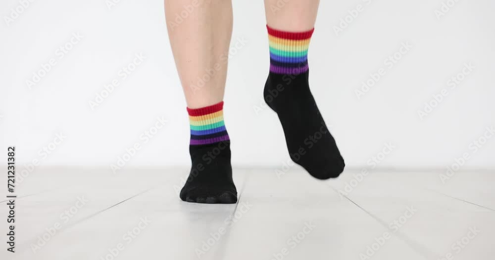 Person in socks with decorated LGBT flag is jumping on floor. Demonstration in support of sexual minorities Person in socks with decorated LGBT flag is jumping on floor. Demonstration in support of sexual minorities