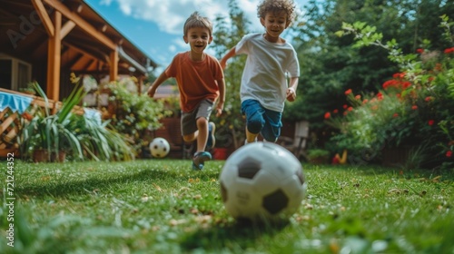 Two Spanish boys 10 years old play football in the summer garden