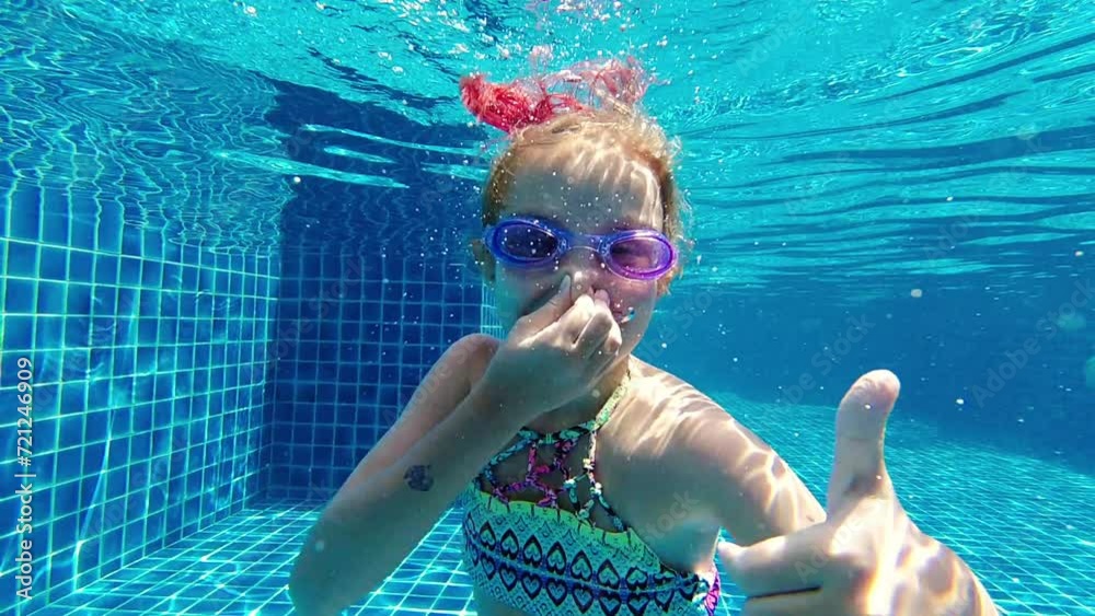 little girl deftly swim underwater in pool