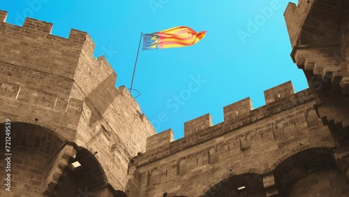 Beautiful flag of the Valencian community waving on top of old castle 