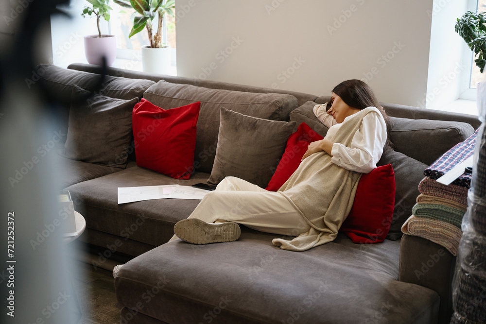 Obraz premium Tired pregnant woman is dozing on soft pillows in relaxation area