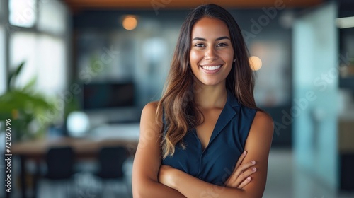 Portrait of smiling young multiethnic woman looking at camera with crossed arms. Successful latin business woman standing