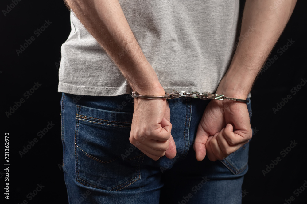 Arrested Man In Handcuffs With Handcuffed Hands Behind Back In Prison