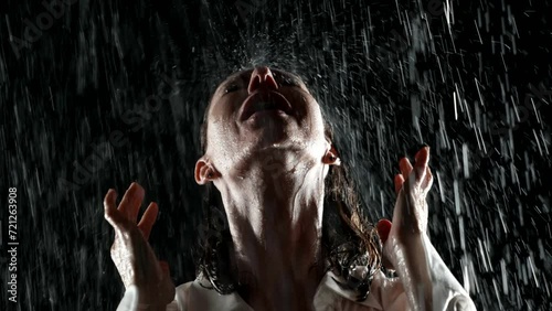 The emblem of the night, a woman bathed in rain in her white shirt, embodies passion and sensuality. Her portrait is a picture of a mixture of tenderness and audacity under the night sky photo