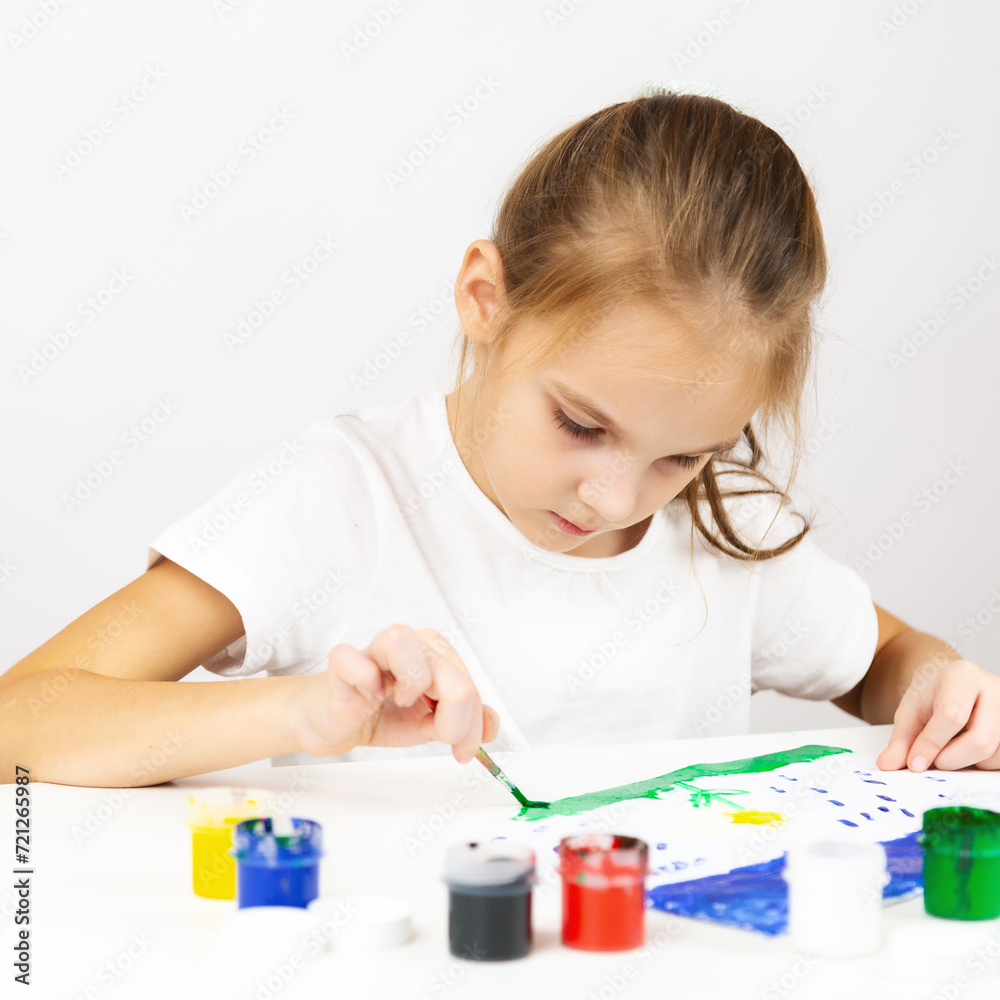 Portrait of a girl painting during an art class on at table indoors, additional drawing courses. Portrait of a girl painting during an art class on at table indoors, additional drawing courses.