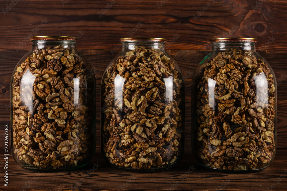 The walnut kernels in jar on wooden background. The walnut kernels in jar on wooden background.