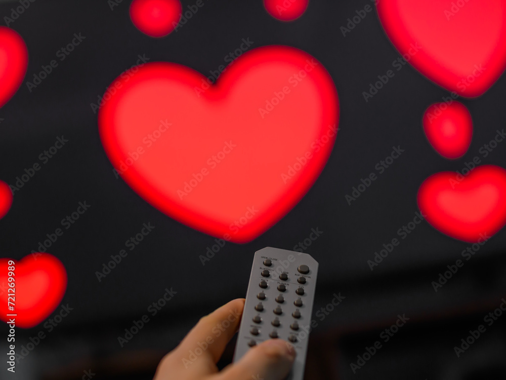 Pilot telewizora i ekran tv z włączonym filmem romantycznym, serduszka na ekranie - obrazy, fototapety, plakaty 