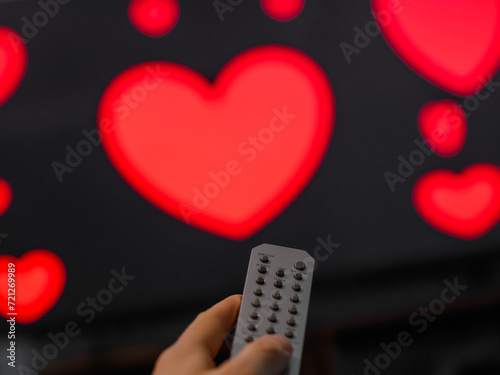 Pilot telewizora i ekran tv z włączonym filmem romantycznym, serduszka na ekranie photo