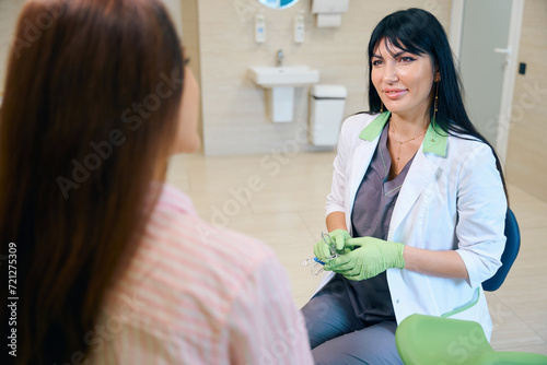 Gynecologist with gynecological mirrors with exhaust pipes looking at woman photo