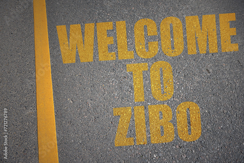 asphalt road with text welcome to zibo near yellow line. photo