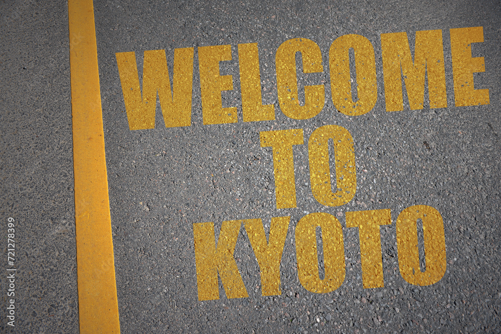 asphalt road with text welcome to Kyoto near yellow line.