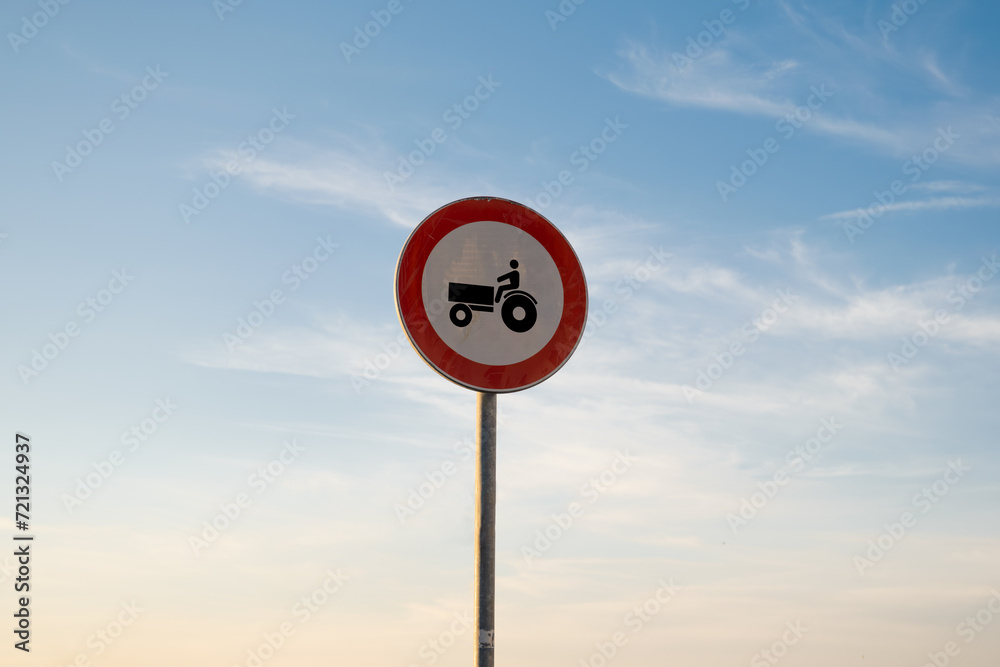 No entry for tractors traffic sign, isolated sunset sky.