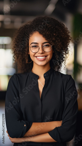 Portrait of smiling african american businesswoman in eyeglasses looking at camera in office