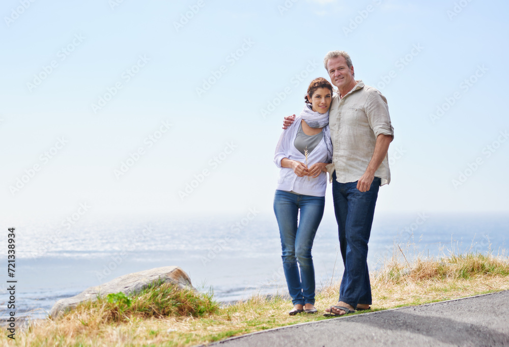 Mature couple, hug and portrait at the sea, ocean or walk on road at the beach in retirement mockup. Summer, vacation or holiday with old man and woman together with love and support in marriage