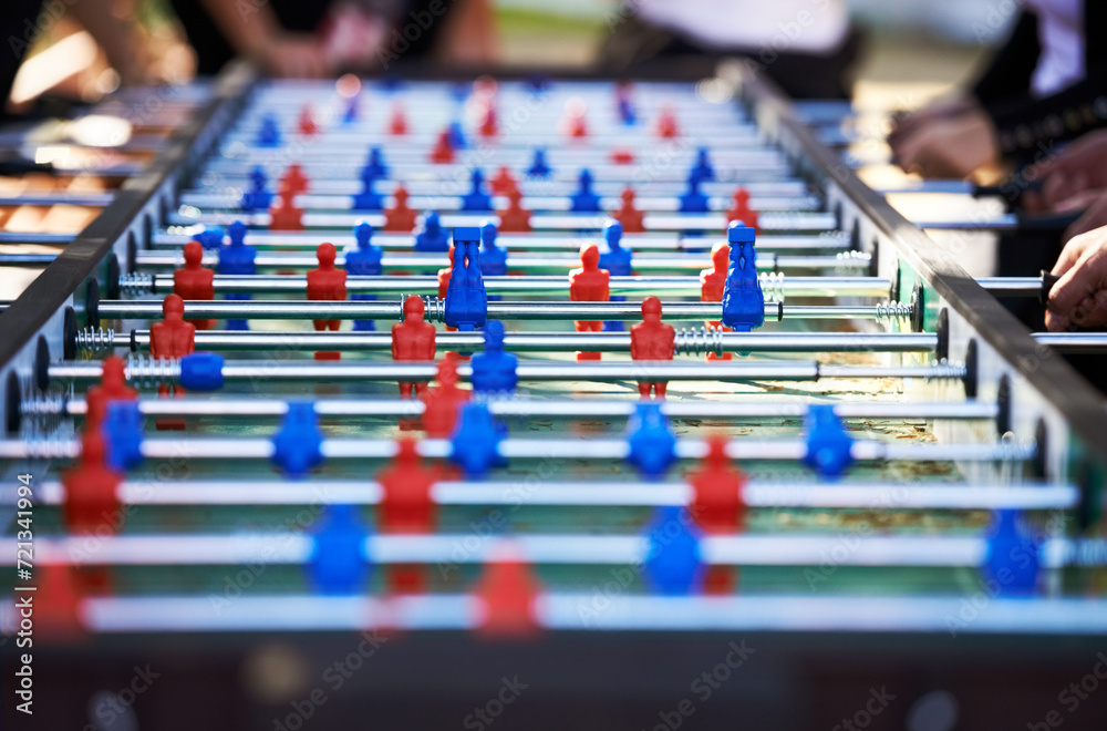 Obraz premium Foosball table, competitive and leisure with people playing a game outdoor at a music festival together. Party, event or social gathering with friends at a carnival for tabletop soccer or football