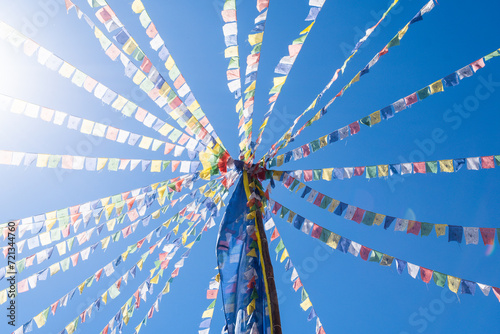 colorful prayer flags fluttering on a blue sky background photo