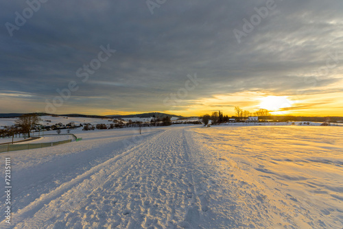 Schneebedeckter Weg im Erzgebirge mit Sonnenuntergang