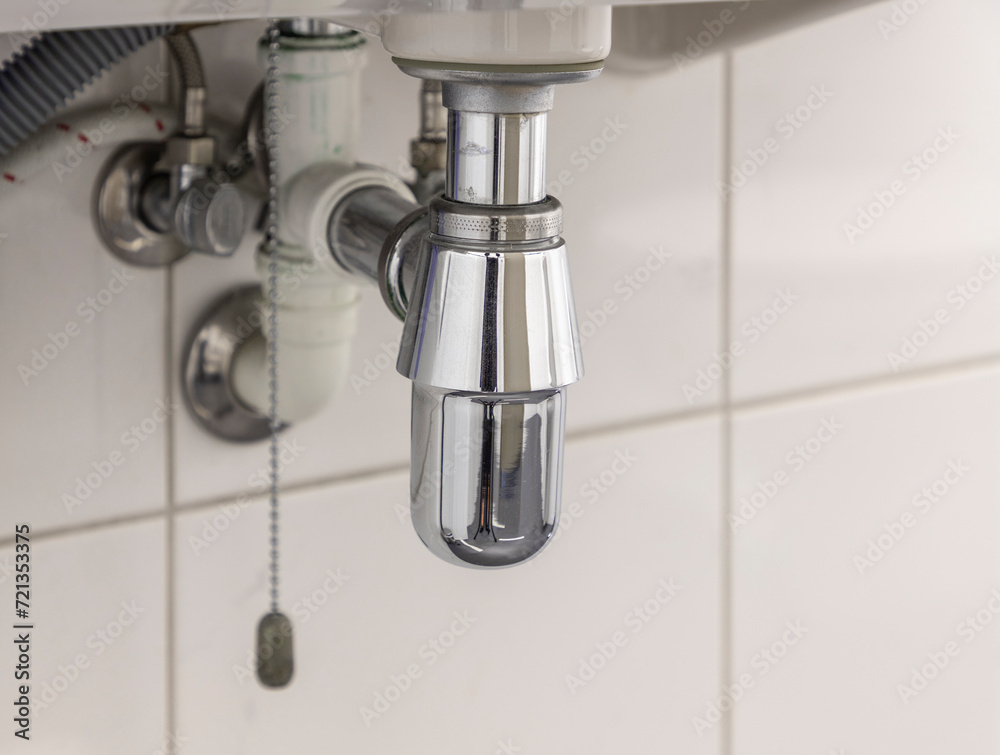 Chrome siphon under the sink, plumbing fixtures, close-up. Chrome siphon under the sink, plumbing fixtures, close-up.