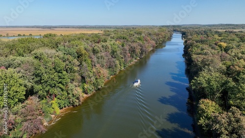Boat traveling through green landscape with Seneca River in up state New York at Montezuma Wildlife Refuge
