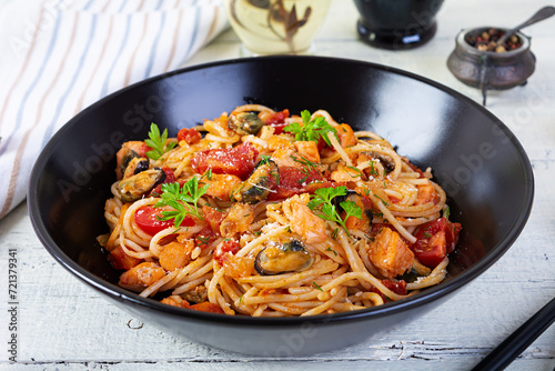 Seafood pasta with clams, salmon and tomatoes. Spaghetti with seafood cocktail