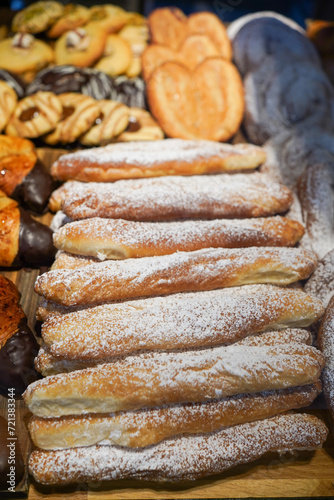 Assorted powdered eclairs and pastries on display.