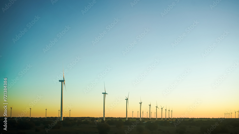 Obraz premium Wind turbines against a clear sky at dusk, symbolizing clean energy.