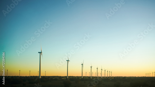 Wind turbines against a clear sky at dusk, symbolizing clean energy. © AdriFerrer