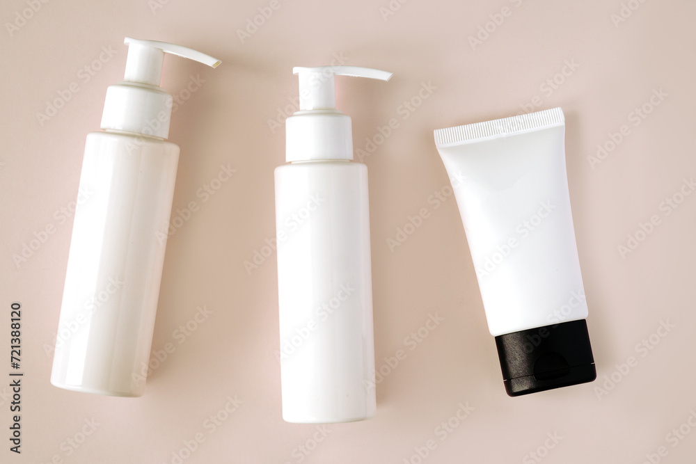 White bottles and tube of cosmetic products background White bottles and tube of cosmetic products background