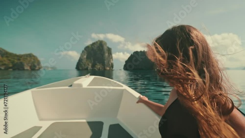 Girl sailing speed boat slow motion wind blow long hair. Young adult female enjoying fast ride on a motorboat. Feeling alive, and free concept. Travel holidays tour to Philippines, El Nido Islands. photo