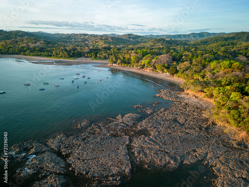 Aerial view of rocky coast line in Santa Catalina with boats and tropical forest in background
