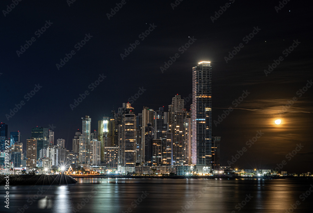 Long exposure city skyline of Panama City at night with glowing moon as wallpaper