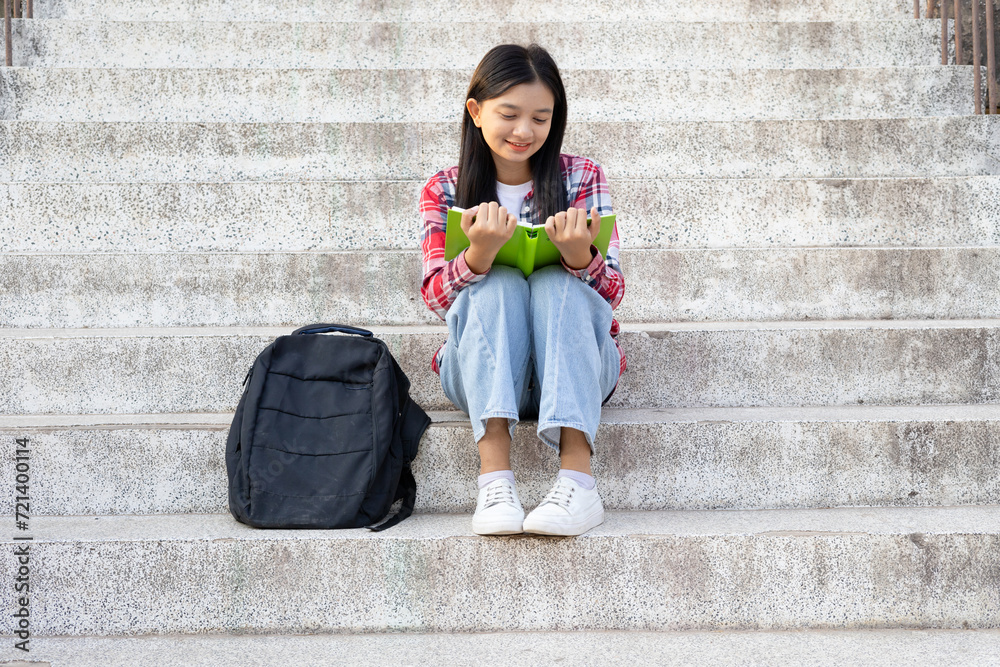 Portrait student young girl reading a book and siting on stair with ...