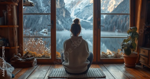 A Young Woman Embraced by Warmth  Admiring the Wintry Scene Through a Large Cabin Window
