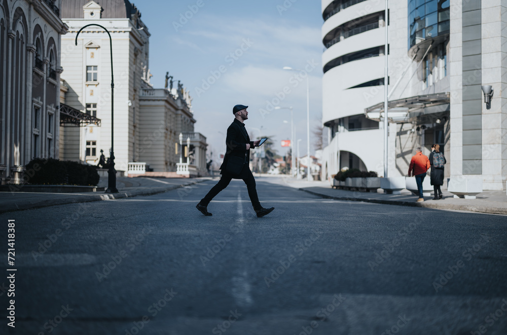 A stylish man in business attire briskly walks across a city street with classic and modern architecture surrounding him.