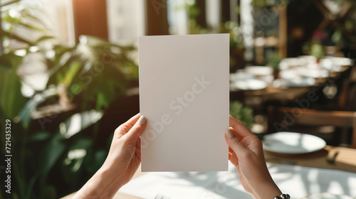 Female hands with blank menu on blurred cafe interior