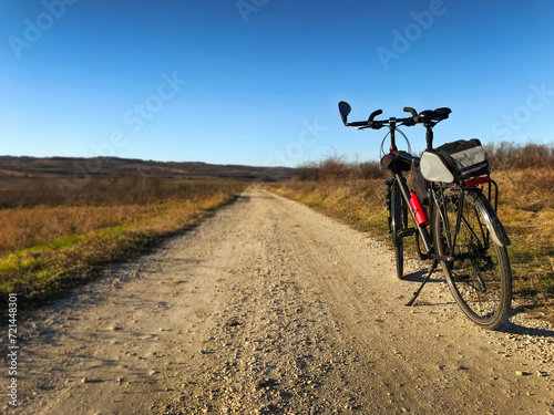 Photo of black color touring bicycle parked at country side road on sunny winter day