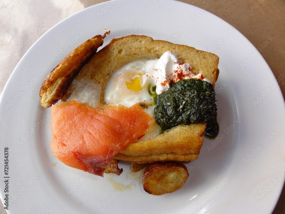 Breakfast with fried egg, smoked salmon and spinach on white plate Breakfast with fried egg, smoked salmon and spinach on white plate