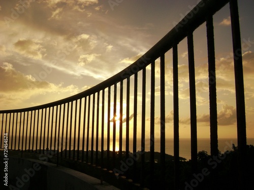 Close up shot of a steel fence with a sunset view.