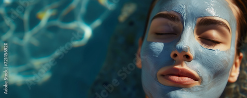 Woman with a clay mask relaxing in pool water. Image for spa resort advertisement, health and beauty magazine. Lifestyle concept. Banner with copy space. 