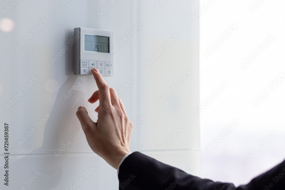 The air conditioning and heating control panel for the apartment and office is located on a white wall. The air conditioning and heating control panel for the apartment and office is located on a white wall.