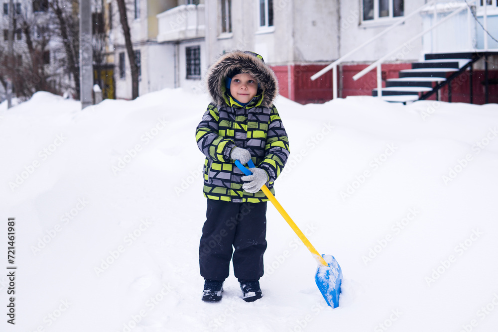 Fototapeta premium child on a walk in winter in cold snowy weather in an urban environment