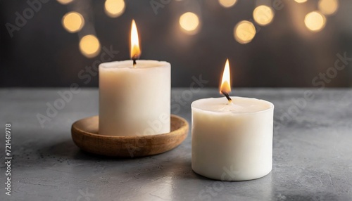 Two burning soy candles  gray cement background.