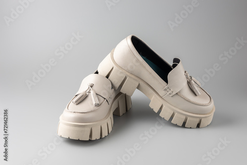 фотографія Trendy fashionable beige leather   women pair platform loafers on neutral grey background