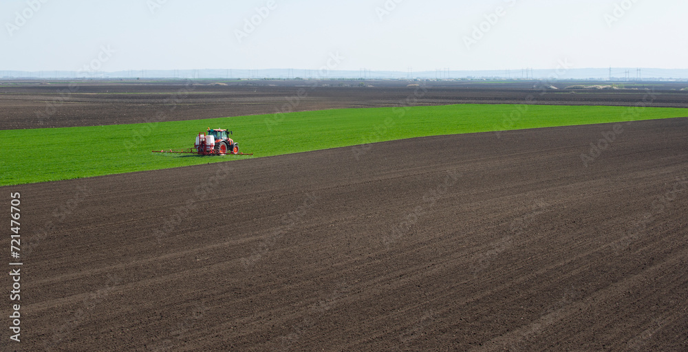 Tractor spraying wheat in field Tractor spraying wheat in field