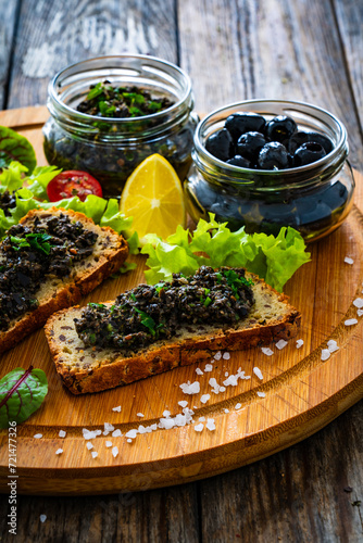 Tasty bruschetta with tapenade on wooden table
