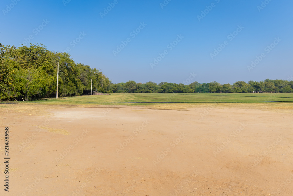 isolated green playing ground with bright blue sky at day from flat angle