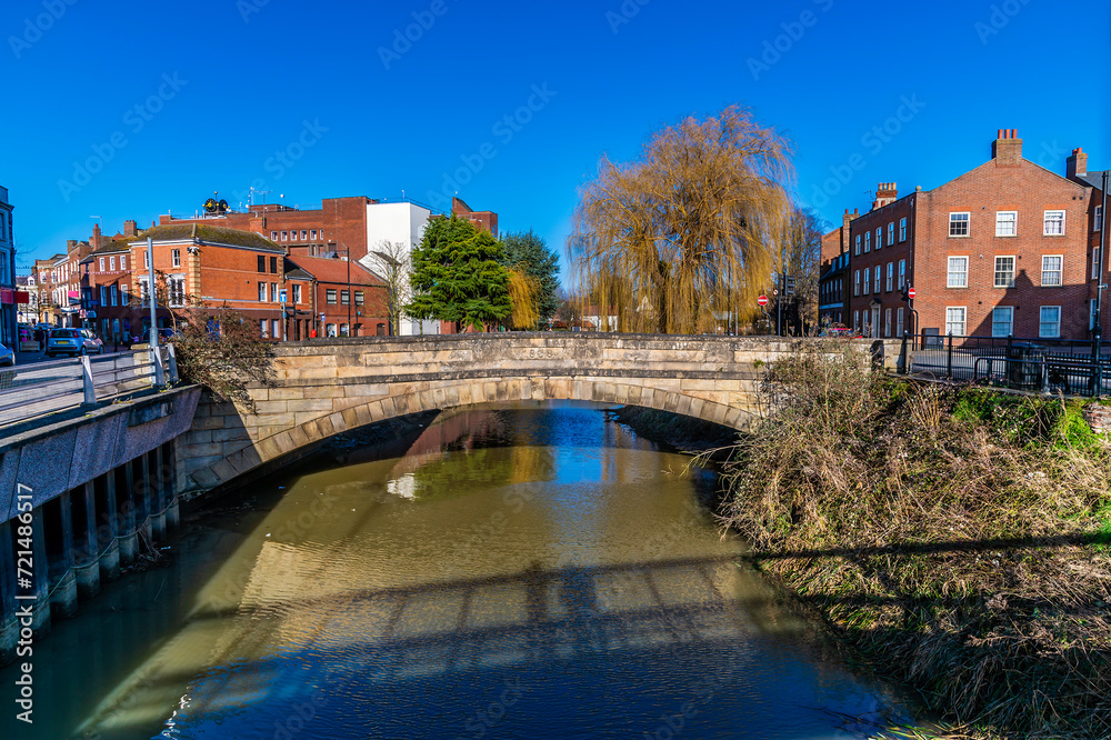 A view up the River Welland towards the Church Street bridge in the centre of Spalding, Lincolnshire on a bright sunny day