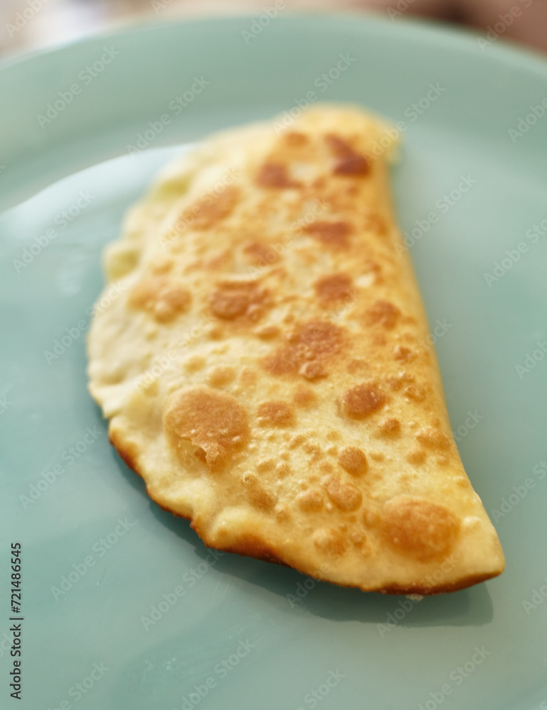 A dish of dough and meat lies on a plate A dish of dough and meat lies on a plate