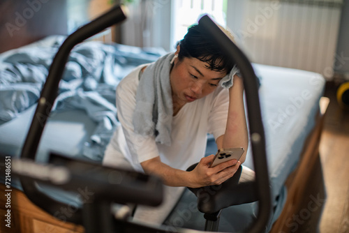 Smiling woman using smartphone after home workout