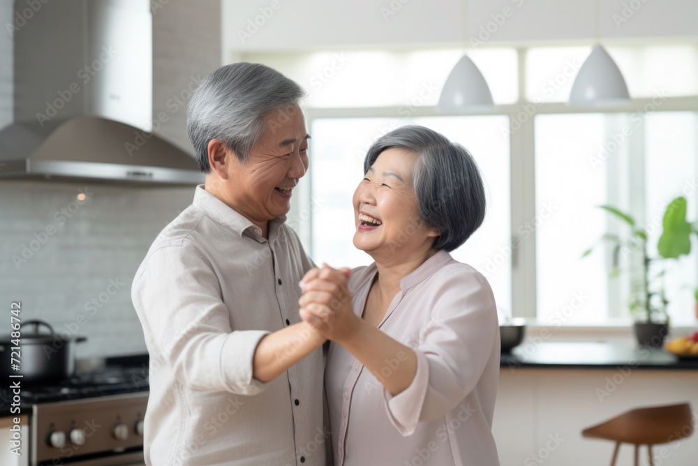Asian multiracial married senior mature couple dancing in the kitchen Asian multiracial married senior mature couple dancing in the kitchen